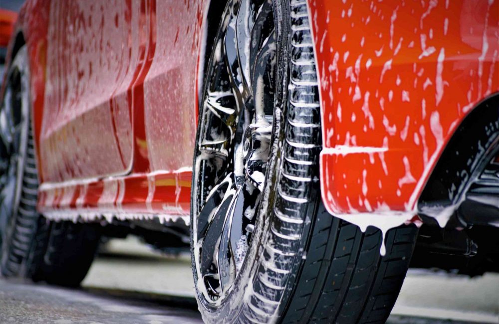 Czerwone auto oraz felgi podczas mycia
